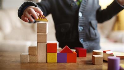 Kind bouwt toren met blokjes