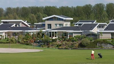 De golfbaan met op de achtergrond woningen van het Flevo Golf Resort